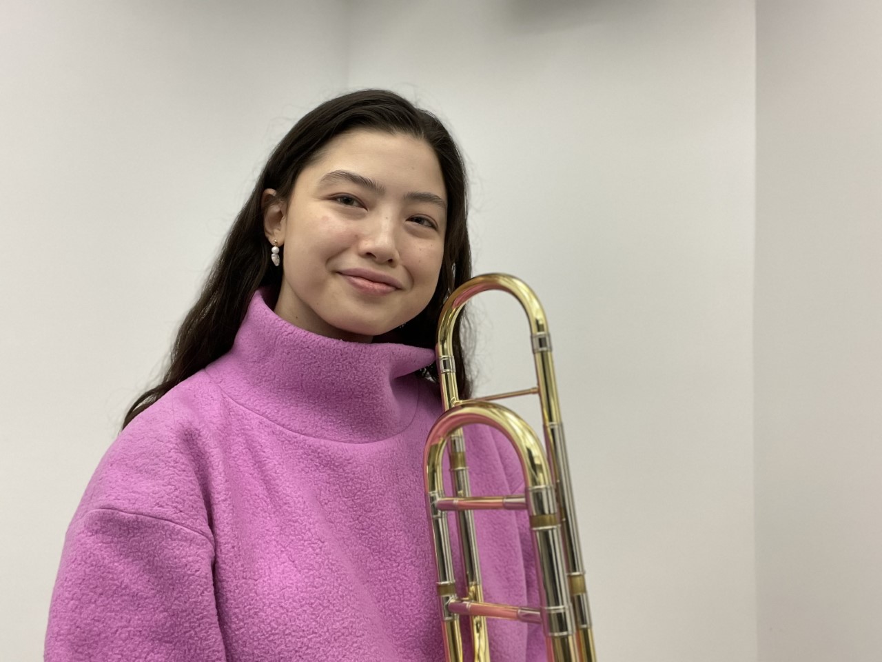 Isabella Lau smiling with her trombone.
