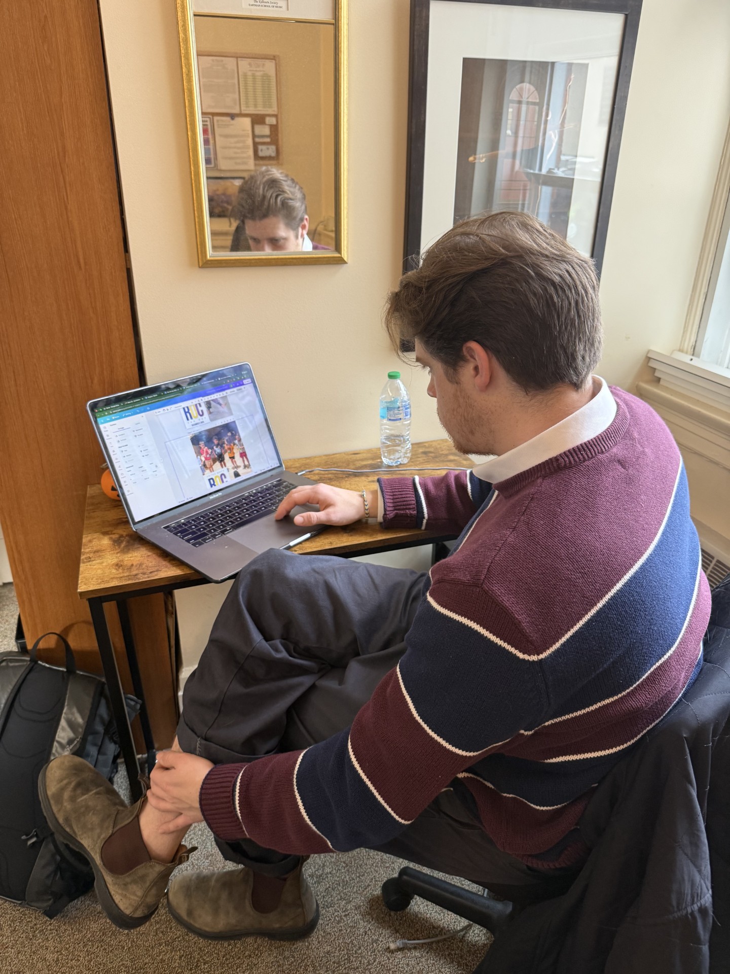 Joe Himmeberg working on a Canva project at the Hochstein Development office.